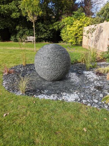 1m Grey Watersphere™ set on a shallow pool and surrounded by matching loose slate chippings